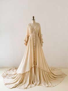 an antique dress is displayed on a mannequin's head stand in front of a white wall