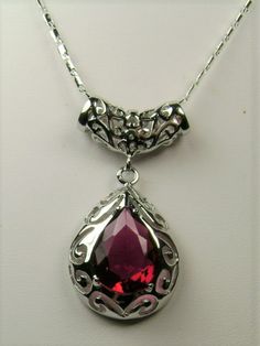 Simulated Red Ruby PendantBig Teardrop Design#P28This is a stunning Victorian inspired pendant necklace. This beautiful necklace is handcrafted from sterling silver. The flawless 6 carat man-made red ruby is a pear cut gemstone. Measurements are 16mm in length and 12mm in width. The 1.5mm sterling silver chain is 18" long (Chain may be different than pictured). The entire pendant is 1-11/16" long by 13/16" wide. The pendant & necklace are marked 925 for sterling silver. Notice the beautiful craf Elegant Pear-shaped Ruby Jewelry, Classic Red Teardrop Pendant Jewelry, Silver Pear-shaped Jewelry For Valentine's Day, Pear-shaped Silver Jewelry For Valentine's Day, Red Teardrop Gemstone Drop Necklace, Red Pear-shaped Necklace For Gift, Classic Red Teardrop Pendant Necklace, Pear-shaped Gemstone Jewelry For Valentine's Day, Pear-shaped Ruby Jewelry Gift