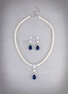 a necklace and earring set with white pearls, blue sapphires and diamond drops