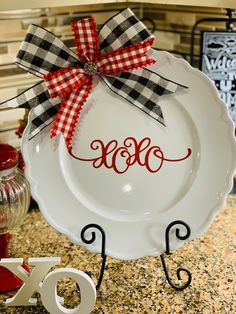 a white plate with the word monogrammed on it and a red ribbon tied around it