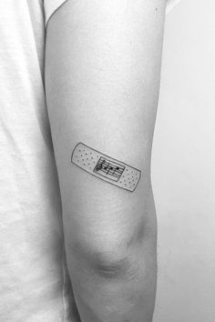 a black and white photo of a person's arm with a tattoo on it