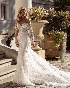 a woman in a wedding dress standing outside