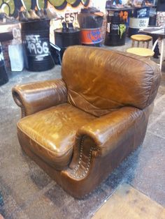 a brown leather chair sitting on top of a cement floor