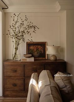 a living room with couches and a painting on the wall above it's dresser