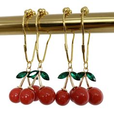 three cherries hanging from a gold hook