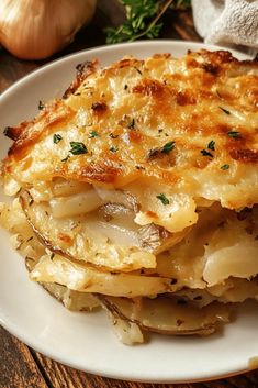 a white plate topped with food on top of a wooden table next to onions and garlic