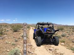 a blue utv driving down a dirt road