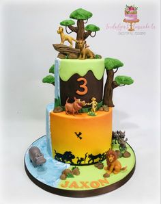 a three tiered cake decorated with animals and trees