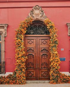 an ornate wooden door surrounded by orange flowers