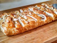 a close up of a pastry on a cutting board with almonds and other toppings