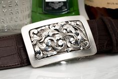 The Mason Dufrene buckle fits all 1.5" belt straps 14k Sterling silver scrollwork on a hand-engraved sterling base Please don't hesitate to call or email us with any questions. 970-688-5339 Cool Belt Buckles, Tie Ideas, Alligator Belt, Buckle Bracelet, Hand Engraving, Belt Buckle, Mens Casual Shoes, Belt Buckles, Classic Black