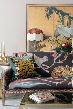 a living room scene with focus on the couch and decorative wall hangings behind it