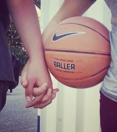 two people holding a basketball in their hands