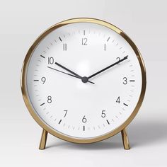 a white and gold clock with black hands