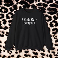 I Only Date Vampires tongue in cheek 90s style crewneck sweater. Perfect for those with a love for the mysterious and supernatural. 🖤 For oversized fit size up 2 sizes.  🖤 Medium-heavy fabric blend of 50% cotton and 50% polyester 🖤 Made using 100% ethically grown US cotton. Each item is hand printed to order, meaning no wastage!  Exchanges are accepted for a different size. If you have any questions about sizing please don't hesitate to reach out! I Only Date Vampires Halloween Crewneck Sweat Halloween Punk Style Streetwear Sweater, Alternative Style Halloween Sweater For Streetwear, Punk Halloween Sweater For Streetwear, Alternative Long Sleeve Halloween Sweatshirt, Grunge Halloween Sweater For Streetwear, Grunge Crew Neck Sweater For Halloween, Alternative Halloween Sweatshirt With Letter Print, Punk Halloween Sweatshirt With Letter Print, Alternative Style Letter Print Sweatshirt For Fall