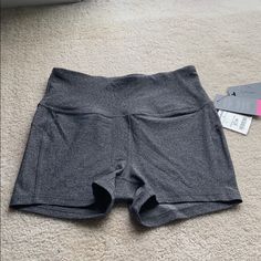 a pair of gray shorts sitting on top of a carpet next to a white box