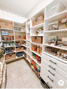 an organized pantry with white shelving and lots of baskets on the bottom shelfs