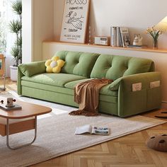 a living room with a green couch and coffee table on the floor next to a window