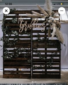 a wooden sign that says the bride and groom on it with some plants in front of it