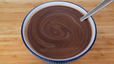 a close up of a cup of coffee on a wooden table with a spoon in it