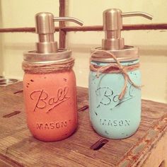 two mason jars with soap dispensers are sitting on a wooden countertop