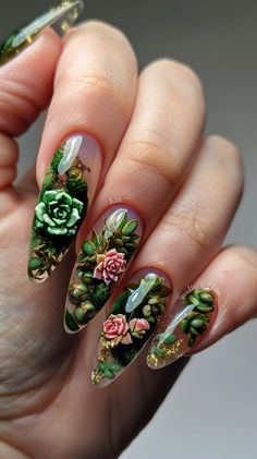 a woman's hand with green and pink flowers on it, holding onto her nails