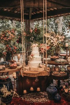 a wedding cake sitting on top of a table next to other cakes and vases