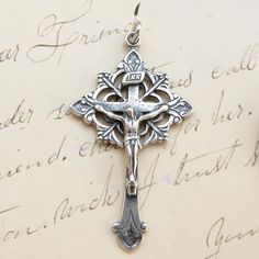 Size: 1 5/8 x 7/8 inch Material: Sterling silver This beautiful crucifix is decorated in the art nouveau style. The ends are budded and scrolled with an open-work trefoil framing the center. It's a very nice size to wear on a chain and not too heavy. The medal was cast in sterling silver from an antique medal in the Rosa Mystica Collection so it shows all the beauty and history of the original piece. It comes with a matching holy card in an organza gift bag, ready for gift-giving, and was made i Silver Crucifix For Wedding, Rosa Mystica, Art Nouveau Style, Organza Gift Bags, Atlanta Ga, Gift Bag, Belly Button Rings, Art Nouveau, Atlanta