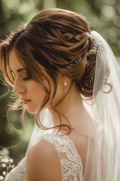 a woman in a wedding dress with a veil on her head and flowers in her hair