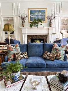 a living room filled with blue couches and lots of pillows on top of them