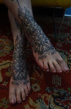 a person with a tattoo on their foot and feet is standing in front of a rug