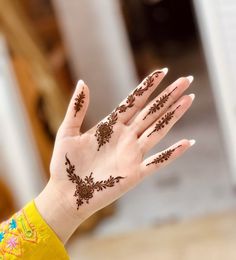 a woman's hand with henna tattoos on it