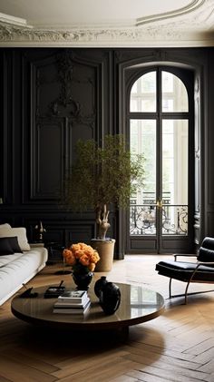 a living room with black walls and wooden flooring, a coffee table in the center