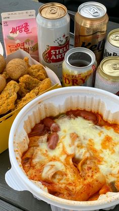 a table topped with lots of food next to cans of soda and other foods on top of it