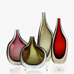 three different colored vases sitting next to each other on a white surface with reflections