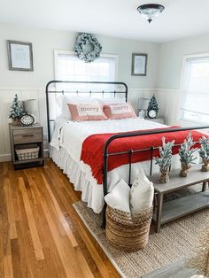 a bed room with a neatly made bed and some plants on the side of the bed