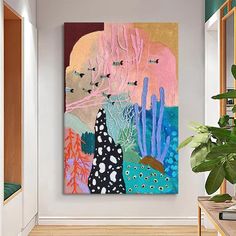 a painting hanging on the wall next to a potted plant in a living room