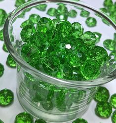 a glass bowl filled with green crystal beads