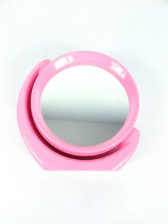 a pink mirror sitting on top of a white table