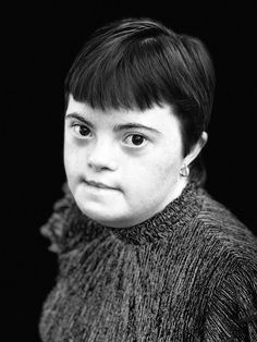 a black and white photo of a young woman with short hair wearing a turtle neck sweater