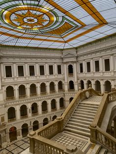 the inside of a large building with many windows and stairs leading up to an atrium