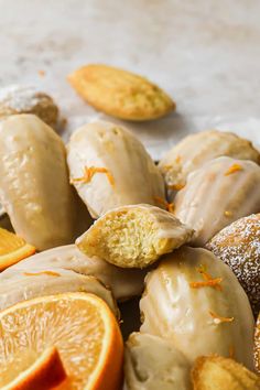 an assortment of pastries with orange slices and powdered sugar