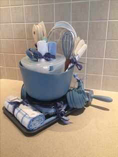 a kitchen counter with blue dishes and utensils on it, including a mixing bowl