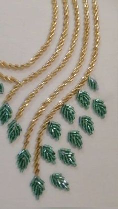 green and gold necklaces with leaves hanging from the end of each beaded strand