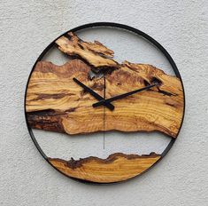 a clock made out of wood on the side of a building with black hands and numbers