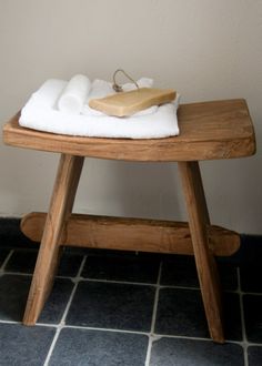 a wooden stool with a white towel on it