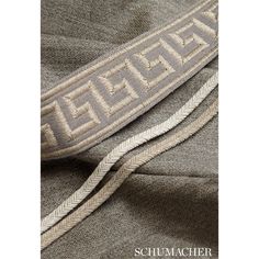 a close up view of the side of a gray and white sweatshirt with an embroidered logo