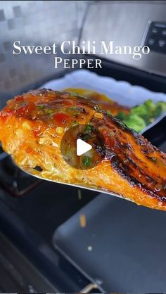 a person holding up a piece of food in front of an oven with the words sweet chili mango pepper on it