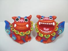 two red and blue figurines with big eyes