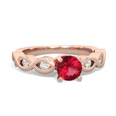 a rose gold ring with an oval ruby stone and two diamonds on the band, set in